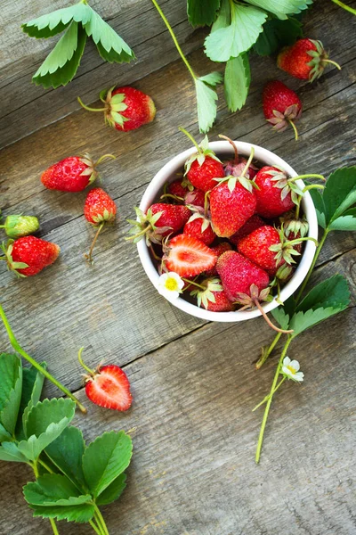 Verse aardbeien in een kom op een houten rustieke tafel. Bovenaanzicht — Stockfoto