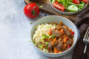 Sağlıklı beslenme konsepti. Bulgur sa 'da sebzelerle pişirilmiş biftek.