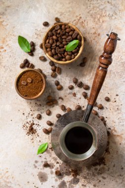 Morning coffee concept. Turkish coffee in Turk and coffee beans on a stone or slate countertop. Top view flat lay background.  clipart
