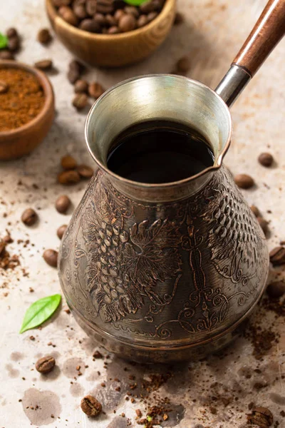 Morning coffee concept. Turkish coffee in Turk and coffee beans on a stone or slate countertop