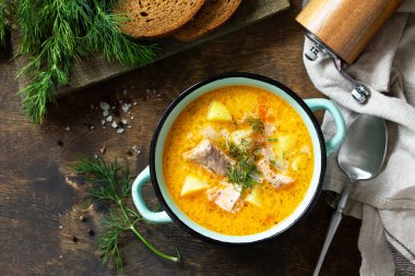 Norveç mutfağı. Kırsal ahşap bir masada kremalı ve somonlu çorba. Üst görünüm düz arkaplan.