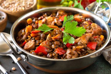 Hint yemeği, otantik Hint yemeği, yakın plan. Geleneksel Hint baharatlı yeşil mercimek et, baharat ve taş bir masada otlar..