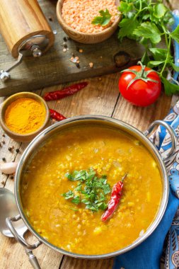 Hint yemeği, gerçek bir Hint yemeği. Geleneksel Hint baharatlı mercimek püre çorbası ve kırsal bir masada otlar..