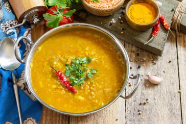 Hint yemeği, gerçek bir Hint yemeği. Geleneksel Hint baharatlı mercimek püre çorbası ve kırsal bir masada otlar. Boşluğu kopyala.