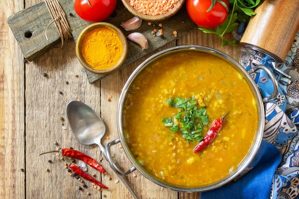 Indian food, a real Indian dish. Traditional Indian spicy lentil puree soup with herbs on a rustic table. Top view flat lay background.