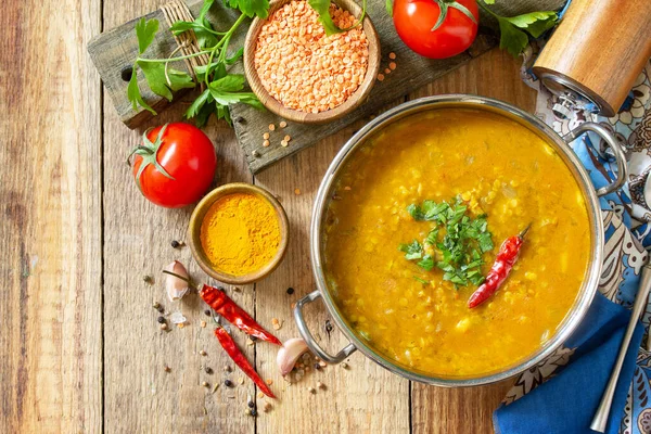 Indian food, a real Indian dish. Traditional Indian spicy lentil puree soup with herbs on a rustic table. Top view flat lay background. Copy space