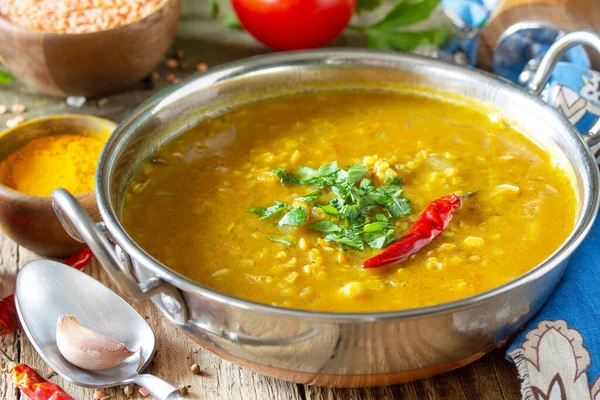 Indian food, real indian dish close-up. Traditional Indian spicy lentil puree soup with herbs on a rustic table