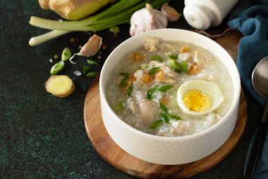 Arroz Caldo Çorbası. Zencefilli tavuklu sıcak çorba ve siyah tezgahta sarımsak. Boşluğu kopyala.