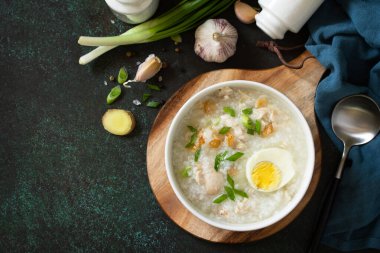 Arroz Caldo Çorbası. Zencefilli tavuklu sıcak çorba ve siyah tezgahta sarımsak. Üst görünüm düz arkaplan. Boşluğu kopyala.