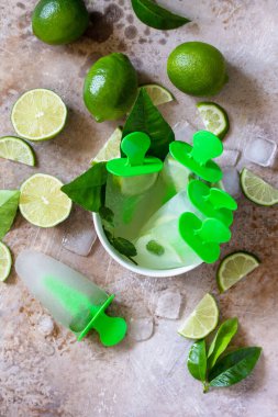 Limon suyu ve nane aromalı ev yapımı buzlu dondurmalar, hafif bir taşta mojito buzu ya da kayrak zemin. Üst görünüm düz arkaplan.