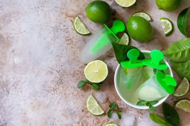 Limon suyu ve nane aromalı ev yapımı buzlu dondurmalar, hafif bir taşta mojito buzu ya da kayrak zemin. Üst görünüm düz arkaplan. Boşluğu kopyala.