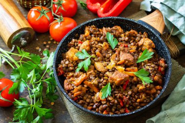 Hint mutfağı. Geleneksel Hint baharatlı yeşil mercimek et, baharat, ahşap bir masada dökme demir tavada otlar..