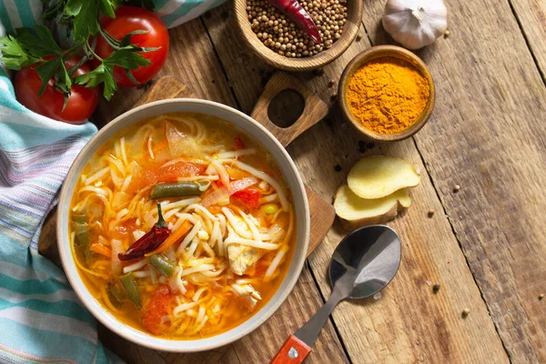Tukpa soup of Indian cuisine. Hot noodle soup with chicken, ginger, cilantro and spices on a deyven wooden table. Top view flat lay background. Copy space — Stock Image Tukpa Soup Indian Cuisine Hot Noodle Soup Chicken Ginger Cilantro Royalty Free Stock Photos