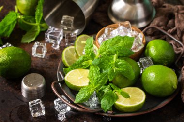 Mojito kokteylini tazeliyorum. Yakın çekim yapıyorum. Nane, kireç, buz malzemesi ve siyah taş arka planda bar aletleri.. 