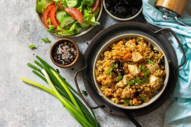 Bulgur pilavı. Sağlıklı beslenme konsepti. Bulgur, tavuklu, sebzeli ve kuru erikli gri taşlı ya da tahta tezgahlı. Üst görünüm düz arkaplan. Boşluğu kopyala.