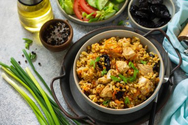 Bulgur pilavı. Sağlıklı beslenme konsepti. Bulgur, tavuklu, sebzeli ve kuru erikli gri taşlı ya da tahta tezgahlı..