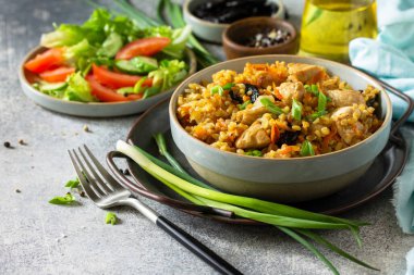 Bulgur pilavı. Sağlıklı beslenme konsepti. Bulgur, tavuklu, sebzeli ve kuru erikli gri taşlı ya da tahta tezgahlı. Boşluğu kopyala.