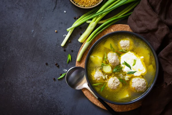 The concept of healthy and diet food. Russian or Ukrainian cuisine. Soup with meatballs, bulgur and pickled cucumbers on a dark stone table. Top view flat lay background. Copy space — Stock Image Concept Healthy Diet Food Russian Ukrainian Cuisine Soup Meatballs Bulgur Royalty Free Stock Photos