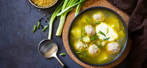 The concept of healthy and diet food. Russian or Ukrainian cuisine. Soup with meatballs, bulgur and pickled cucumbers on a dark stone table. Top view flat lay background. Banner. — Stock Image Concept Healthy Diet Food Russian Ukrainian Cuisine Soup Meatballs Bulgur Royalty Free Stock Images