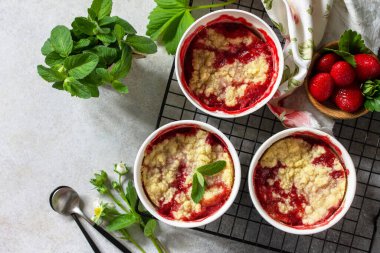 Ev yapımı yaz tatlısı. Çilekler, taş ya da levhadan yapılmış bir masanın üstünde yemek kabında ufalanır. Üst görünüm düz arkaplan. Boşluğu kopyala.