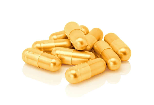 Gouden pil capsule geïsoleerd op witte achtergrond — Stockfoto