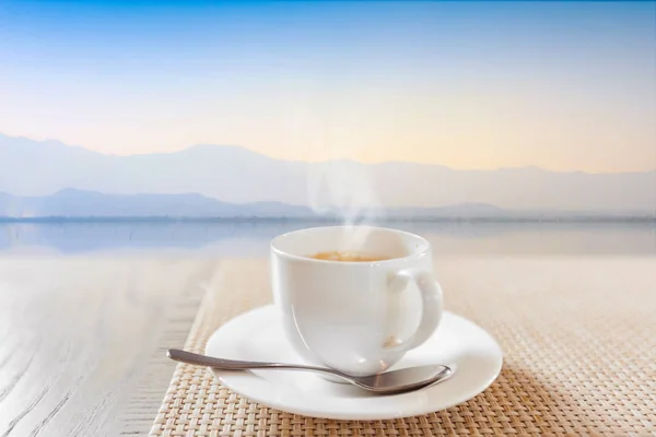 Gorąca kawa w biały cup rocznika drewniany stół — Zdjęcie stockowe