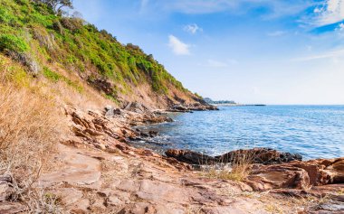 Kayalar ve çayır bulutlu mavi gökyüzü güzel deniz manzarası