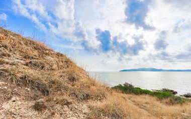 Kayalar ve çayır bulutlu mavi gökyüzü güzel deniz manzarası