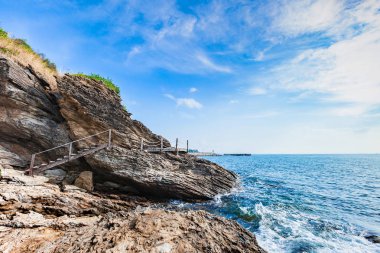 Kayalar ve çayır bulutlu mavi gökyüzü güzel deniz manzarası