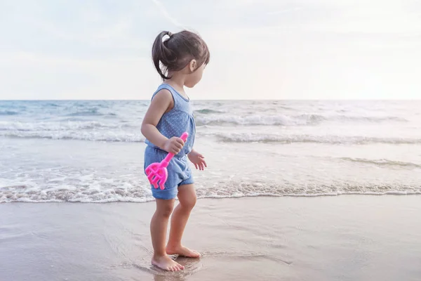 Little girl playing on the beach in sunset — Stock Photo, Image