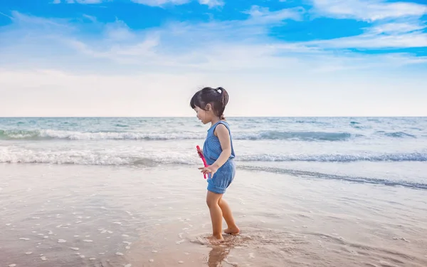 Little girl playing on the beach in sunset — Stock Photo, Image