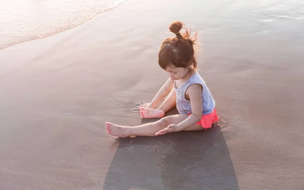 Little girl 2-3 years plays on the beach in sunset — Stock Photo, Image