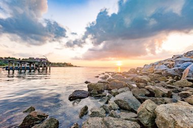 Çok güzel bir sabah Sunrise ahşap tahta iskelesi ile kayalık deniz kıyısı