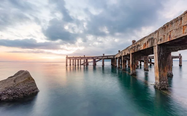 Old pier bridge in beautiful morning sunrise and calmness seascape — Stock Photo, Image