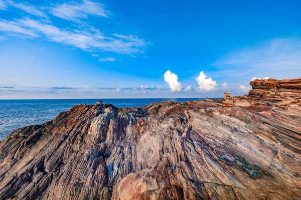 Bord de mer rocheux le matin lever du soleil avec ciel bleu vif et nuages — Photo