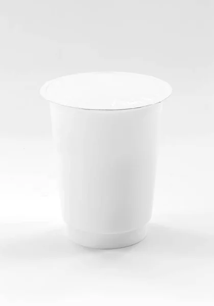 Белая пластиковая чашка для молочных продуктов йогурта на белом фоне — стоковое фото
