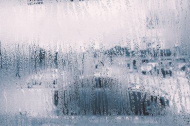 raindrops on glass window in rainy season clipart