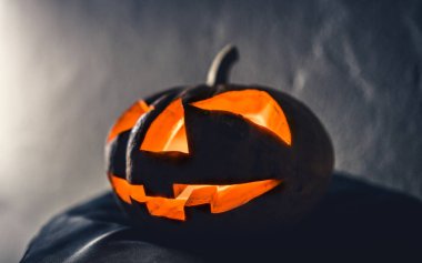 Cadılar Bayramı Balkabağı kafa mum karanlık arka planda ışık ile