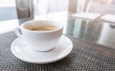 Beyaz fincan sıcak kahve ile sabah masada