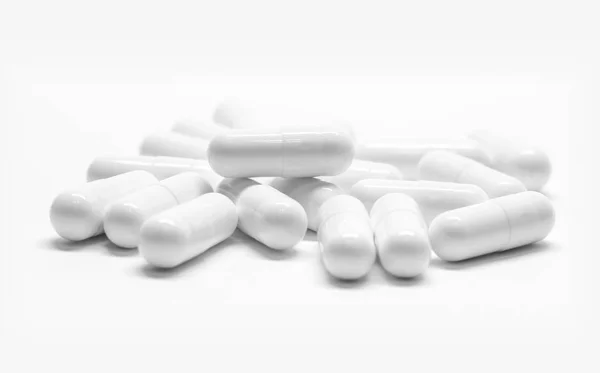 Капсулы белых лекарств на белом фоне — стоковое фото