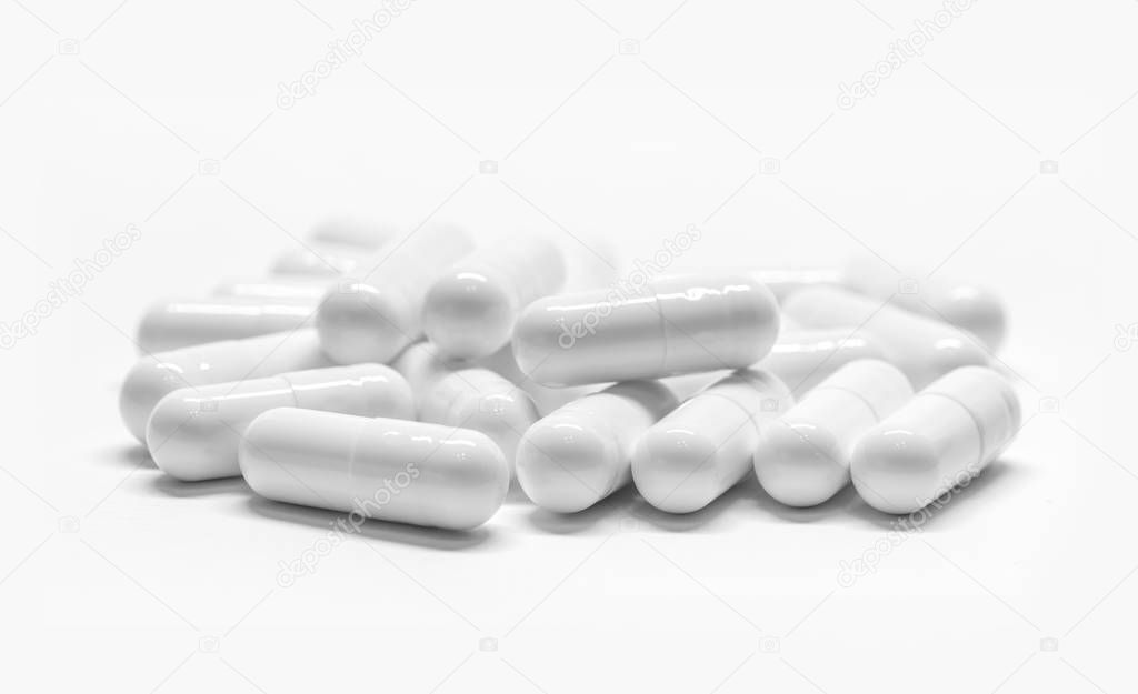 White medicine capsules on white background