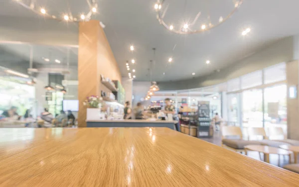 Mesa de madera con barista y clientes en la cafetería o café fondo borroso —  Fotos de Stock
