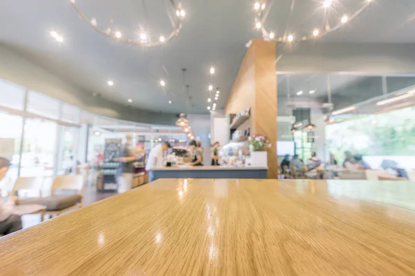 Mesa de madera con barista y clientes en la cafetería o café fondo borroso —  Fotos de Stock