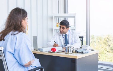 Doktor, ciddi bir şekilde iyileşmesi için hastalara danışmanlık ve muayene yapıyor.