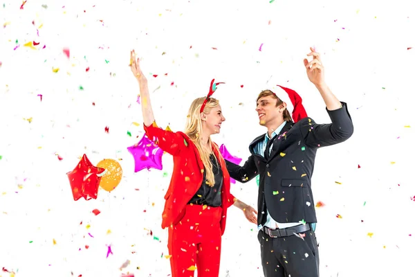 Pareja joven disfruta de la danza con confeti colorido en la fiesta de celebración de año nuevo —  Fotos de Stock
