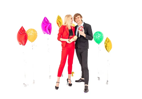 Fiatal boldog pár élvezze pózol színes ballonok és ajándékok szilveszteri ünnepi party — Stock Fotó
