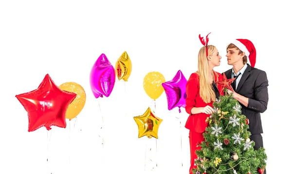 Mutlu çift yeni yıl partisinde renkli balonlarla ve noel ağacıyla poz vermeyi sever. — Stok fotoğraf
