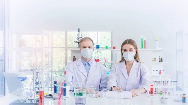 Two scientists working in chemical laboratory