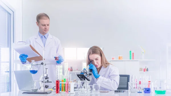 Two scientists working and discus in chemical laboratory — Stock Photo, Image