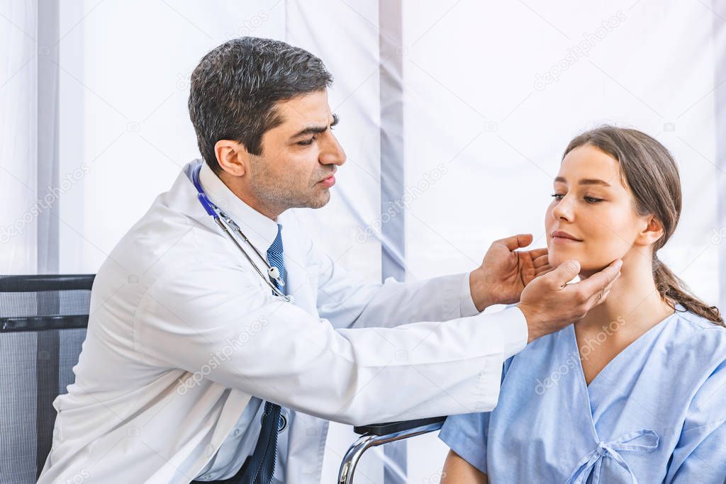 Asian doctor check-up pretty patient for her Thyroid hormones healthy at hospital or medical clinic, Health care and Medical concept